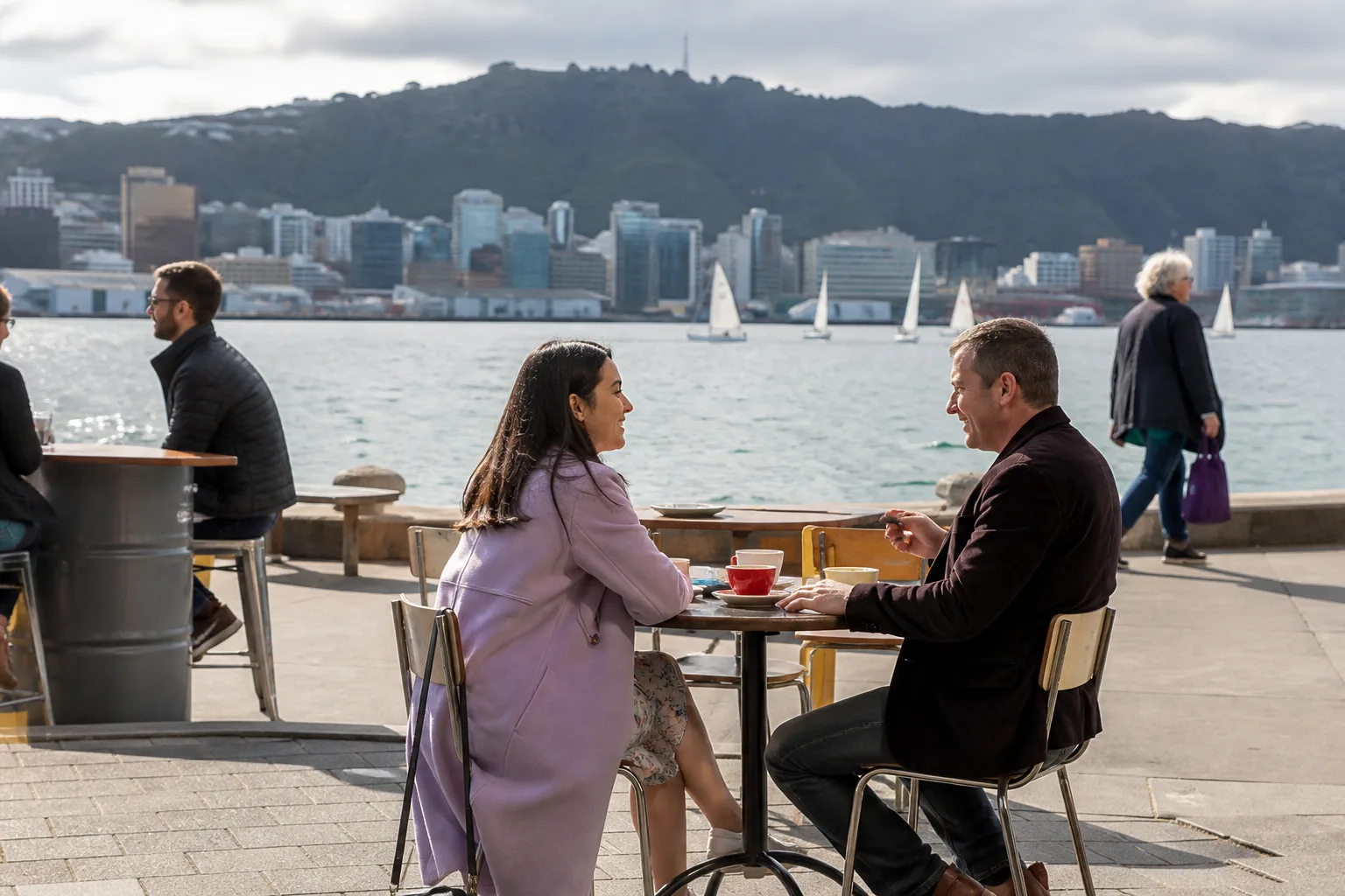 A couple walking beside Wellington Harbour on a first date
